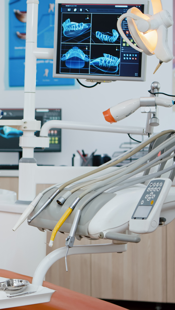 Revealing shot of stomatologist chair with nobody in, x ray images on display. Medical clinic orthodontic room, ready for treatment, modern dentist office for oral care